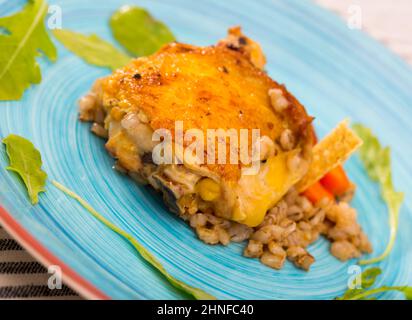 Cosce di pollo al forno con porridge di orzo e rucola Foto Stock