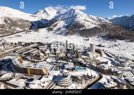 Veduta aerea del villaggio di Sestriere dall'alto, famosa stazione sciistica nelle Alpi occidentali italiane, Piemonte, Italia. Sestriere, Italia - Febbraio, 2022 Foto Stock