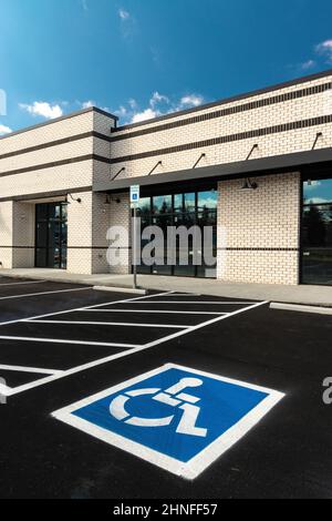 Immagine verticale di un cartello di parcheggio per disabili dipinto in un parcheggio per disabili in un nuovo centro commerciale con negozi al dettaglio in costruzione. Foto Stock