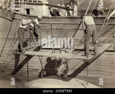 John Wayne (centro, vista posteriore), on-set del film, 'Adventure's End', Universal Pictures, 1937 Foto Stock