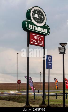 Cartello fuori dal ristorante Milly's e stalla di trote vicino a Machadodorp / eNtokozwen, provincia di Mpumalanga, Sudafrica. C'è anche un cartello per lo Standa Foto Stock