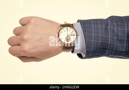 Orologio da polso analogico indossato sulla mano maschile in tuta da lavoro isolato su bianco, scadenza Foto Stock