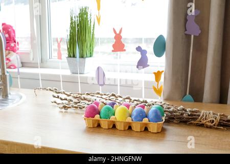 Uova di Pasqua e rami di salice sul banco in cucina Foto Stock