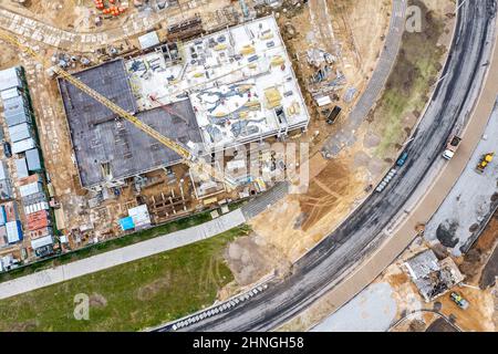 nuova strada in costruzione. cantiere in zona residenziale durante i lavori stradali. vista dall'alto aerea. Foto Stock