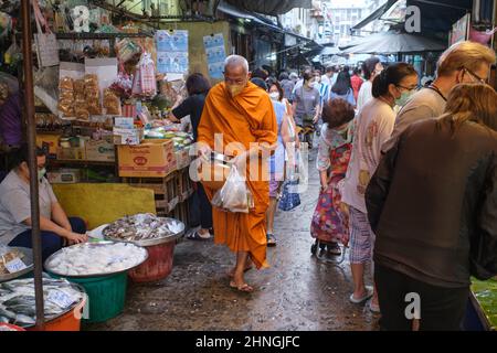 Il suo consueto mattina elemosina rotondo, un monaco buddista, elemosina ciotola in mano, passeggiate attraverso Talat Tok Mor (mercato) a Bangkok, Thailandia Foto Stock