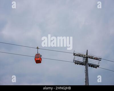 Cabine rosse di funicolare ad Antalya, Turchia sullo sfondo di nuvole di pioggia. Gita in funivia ai punti panoramici delle montagne. Durante il viaggio in funivia i turisti godono di splendide vedute della città e della natura Foto Stock