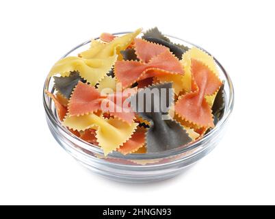 Pasta colorata a forma di arco in una ciotola di vetro su sfondo bianco da vicino Foto Stock