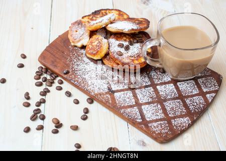 pancake al formaggio con caffè su un tritatutto in legno. Esposizione fatta in casa per la colazione. Foto Stock