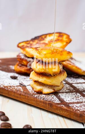 miele gocciolante su pancake al formaggio, vista laterale ravvicinata Foto Stock
