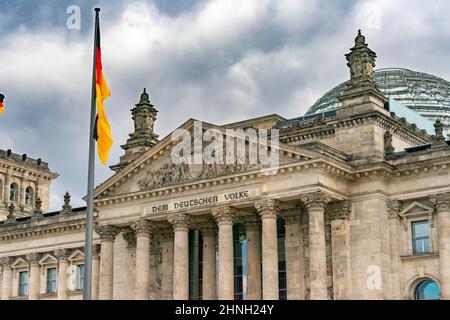 Bandiere tedesche ondeggiavano nel vento nel famoso edificio del Reichstag, sede del Parlamento tedesco (Deutscher Bundestag), in una giornata di sole con la zica blu Foto Stock