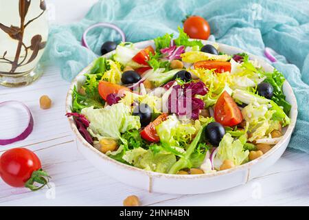 Insalata vegetariana con ceci, pomodori, olive e lattuga. Dieta insalata alimentare Foto Stock