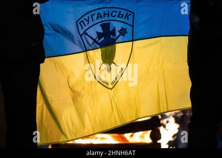 Bandiera dell'Ucraina soprattutto con silhouette di simbolo o logo di Luhansk o Lugansk città vicino al confine con la Russia nella regione contesa Donbass Foto Stock