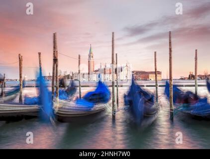 Chiesa di San Giorgio maggiore contro le gondole al tramonto a Venezia Foto Stock