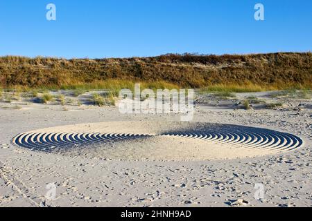 Strani cerchi nella sabbia sulla riva del mare. Giardino di roccia Zen Foto Stock