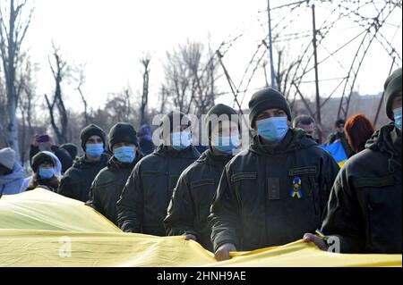 SIEVIERODONETSK, UCRAINA - 16 FEBBRAIO 2022 - i soldati della Guardia Nazionale portano per le strade una lunga bandiera Ucraina per celebrare la Giornata dell'unità, Foto Stock