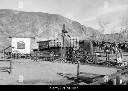 Foto in bianco e nero di macchinari minerari in legno e di un carro trainato da cavalli nella città fantasma del selvaggio West di Calico, San Bernardino County, California, USA Foto Stock