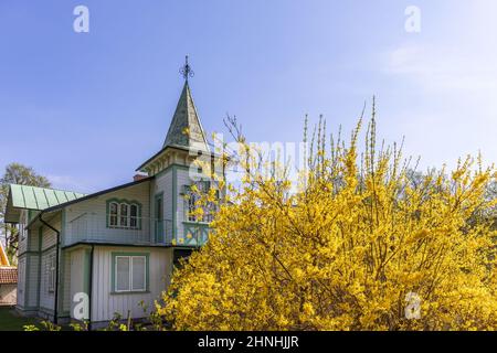 Idilliaca casa in legno con una torre e una fortificazione fiorita Foto Stock