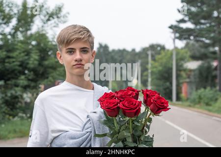 Bell'adolescente tiene un bouquet di rose rosse nelle sue mani. Foto Stock