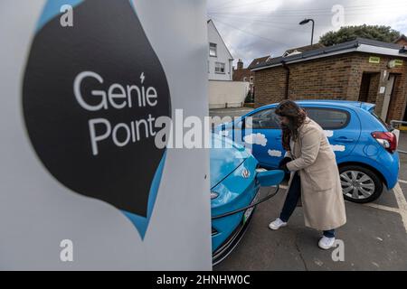 Signora di mezza età che utilizza il punto di ricarica del veicolo "GeniePoint EV Charging" in Hampshire , Inghilterra, Regno Unito Foto Stock