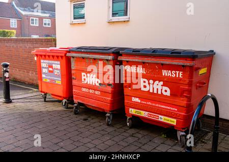 Woodbridge Suffolk UK Febbraio 16 2022: 3 grandi bidoni Biffa rossi seduti in un centro urbano occupato in attesa che il consiglio li raccolga e li svuoti Foto Stock