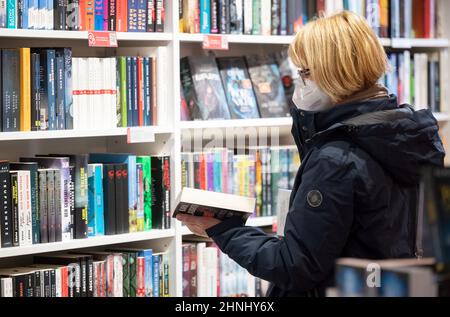 Stoccarda, Germania. 17th Feb 2022. Un cliente naviga in una libreria presso la libreria Osiander. Nonostante la terza cancellazione consecutiva della fiera, il Premio Fiera del Libro di Lipsia verrà nuovamente assegnato quest'anno. (Al dpa: 'Politico e diverso - i candidati per il Premio del Libro di Lipsia') credito: Marijan Murat/dpa/Alamy Live News Foto Stock