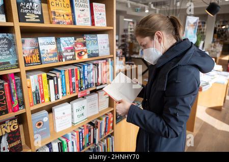 Stoccarda, Germania. 17th Feb 2022. Un cliente sta sfogliando una libreria presso la libreria Osiander. Credit: Marijan Murat/dpa/Alamy Live News Foto Stock