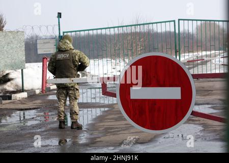 REGIONE DI KHARKIV, UCRAINA - 16 FEBBRAIO 2022 - una guardia di frontiera è in servizio al checkpoint di Zhuravlivka sul confine Ucraina-Russia che rimane chiuso Foto Stock