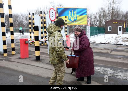 REGIONE DI KHARKIV (UCRAINA) - 16 FEBBRAIO 2022 - una guardia di frontiera e una donna anziana sono raffigurate al checkpoint Hoptivka al confine Ucraina-Russia, Foto Stock