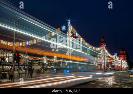 Corse in autobus davanti a Glasgow George Square decorato con luci di Natale. Foto Stock