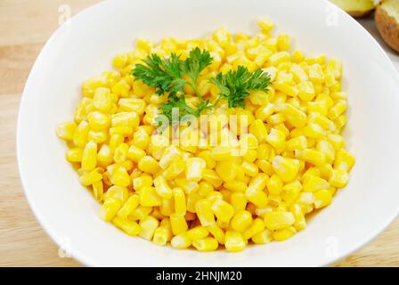 Un piatto laterale di mais giallo dolce in una ciotola bianca Foto Stock