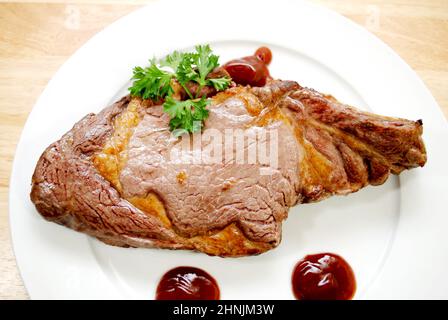 Mediamente rara bistecca di manzo alla griglia su un piatto bianco Foto Stock