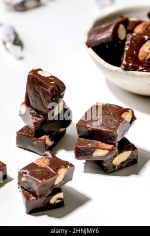 Caramelle al cioccolato al caramello salato fatte in casa alle mandorle dolci su tavola bianca. Regali dolci fatti a mano per tutte le vacanze. Primo piano Foto Stock
