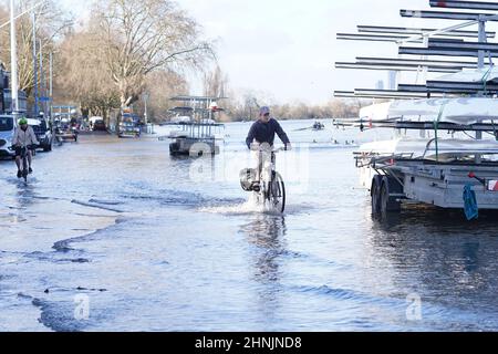 Un ciclista passa attraverso l'acqua alluvione vicino al Tamigi a Putney, Londra dopo Storm Dudley colpito Giovedi notte. Data immagine: Giovedì 17 febbraio 2022. Foto Stock
