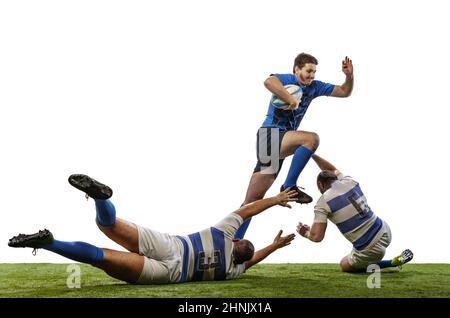 Uomini muscolati, giocatori professionisti di rugby che giocano a calcio di rugby su campo d'erba isolato su sfondo bianco. Sport, attività, salute, hobby Foto Stock