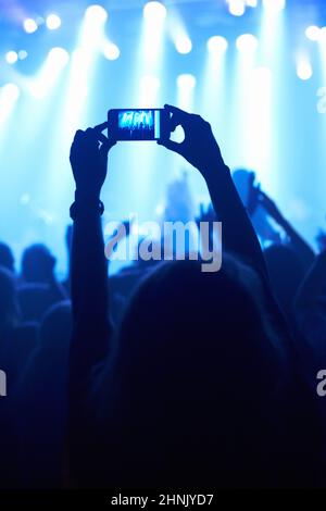 Cattura l'attimo. Una persona che filma la propria band preferita con un telefono con fotocamera. Foto Stock