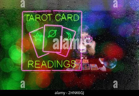 Letture di carte Tarocchi Neon Sign in Window con lettore di carte Tarocchi psichico in background Foto Stock