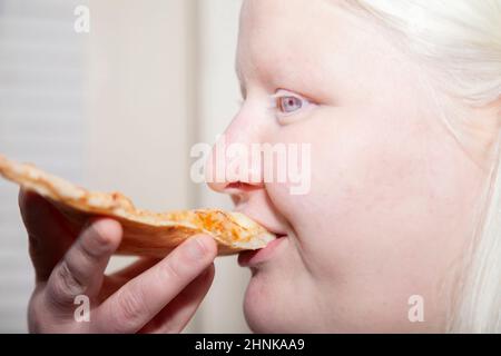 Albino Donna mangiare Pizza indietro Foto Stock