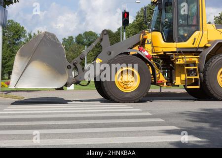 viaggio con escavatore giallo su una strada della città Foto Stock