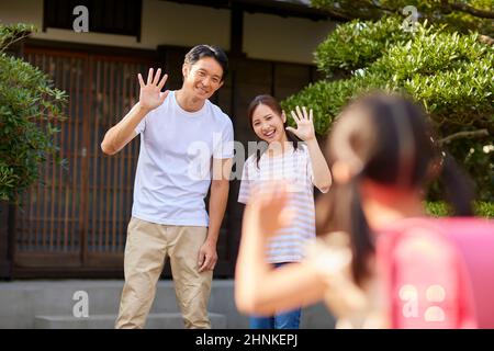 Coppia giapponese che vede fuori il loro bambino Foto Stock