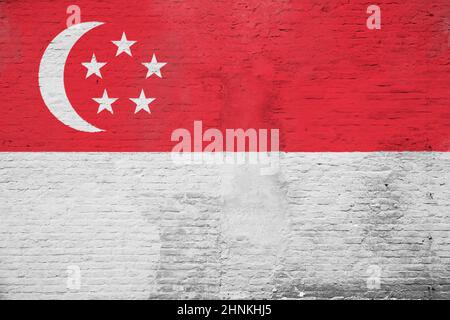 Foto full frame di una bandiera di Singapore dipinta su una parete di mattoni intonacati. Foto Stock