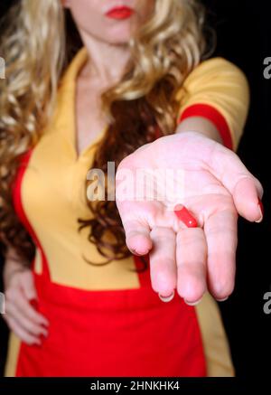 Cameriera con Red Nail Polish Holding Red pill Foto Stock