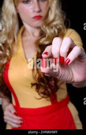 Cameriera con Red Nail Polish Holding Red pill Foto Stock
