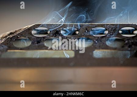 sigarette che non sono completamente sueezed fuori fumo in un posacenere di metallo Foto Stock