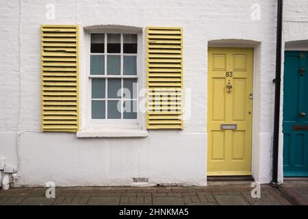 Porte frontali colorate e persiane finestre su case a schiera, Sheen Lane, Londra, Inghilterra, Regno Unito Foto Stock