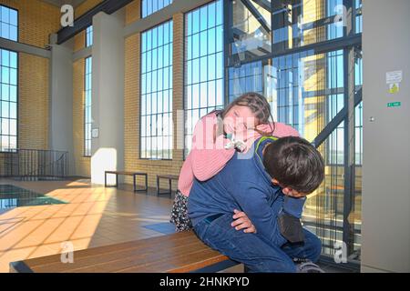 Fratelli stanchi in viaggio con la famiglia. Stazione ferroviaria in Europa. Immagine autentica. Non foto studio Foto Stock