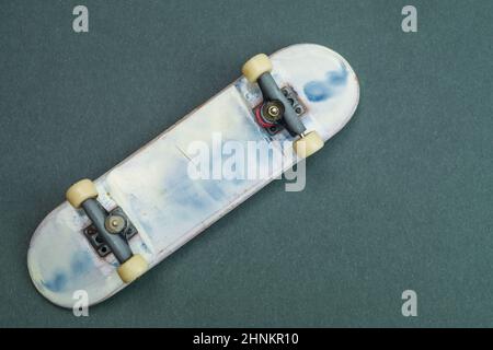 Skateboard piccola su sfondo colorato. Skate minuscolo per le dita. Primo piano su fingerboard. concetto home leisure Foto Stock