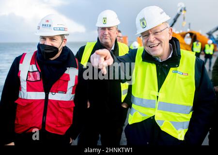 Cuxhaven, Germania. 17th Feb 2022. Stephan Weil (r-l, SPD), Presidente del Ministro della bassa Sassonia, visita il terminal della BLUE Water BREB insieme a Uwe Santjer (SPD), sindaco della città di Cuxhaven, e Arne Ehlers, Amministratore Delegato della Blue Water BREB. Il Presidente del Ministro Weil si informa sul sito della produzione e della movimentazione di componenti utilizzati per turbine eoliche offshore. Credit: Hauke-Christian Dittrich/dpa/Alamy Live News Foto Stock