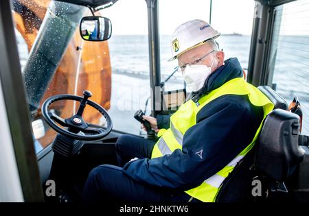 Cuxhaven, Germania. 17th Feb 2022. Stephan Weil (SPD), ministro presidente della bassa Sassonia, siede in un cosiddetto reachstacker presso il terminal Blue Water BREB. Il Presidente del Ministro Weil si informa sul sito della produzione e della movimentazione di componenti utilizzati per turbine eoliche offshore. Credit: Hauke-Christian Dittrich/dpa/Alamy Live News Foto Stock