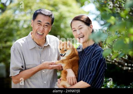 Coppia giapponese senior con il loro cane da compagnia Foto Stock