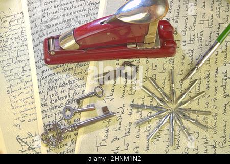 Primo piano degli accessori sulla scrittura vintage. Tasti vintage, pinzatrice, pennini metallici e penna vecchia. Cancelleria d'epoca. Disposizione piatta Foto Stock